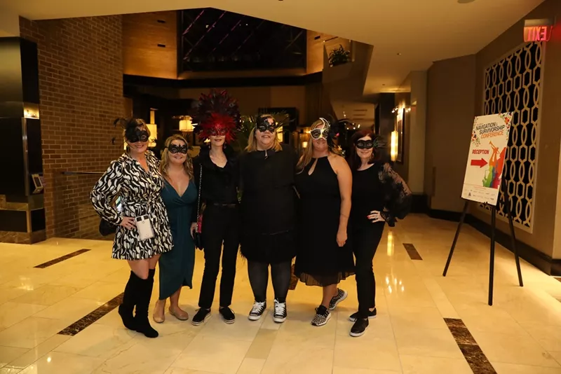 Conference attendees posting with Mardi Gras masks